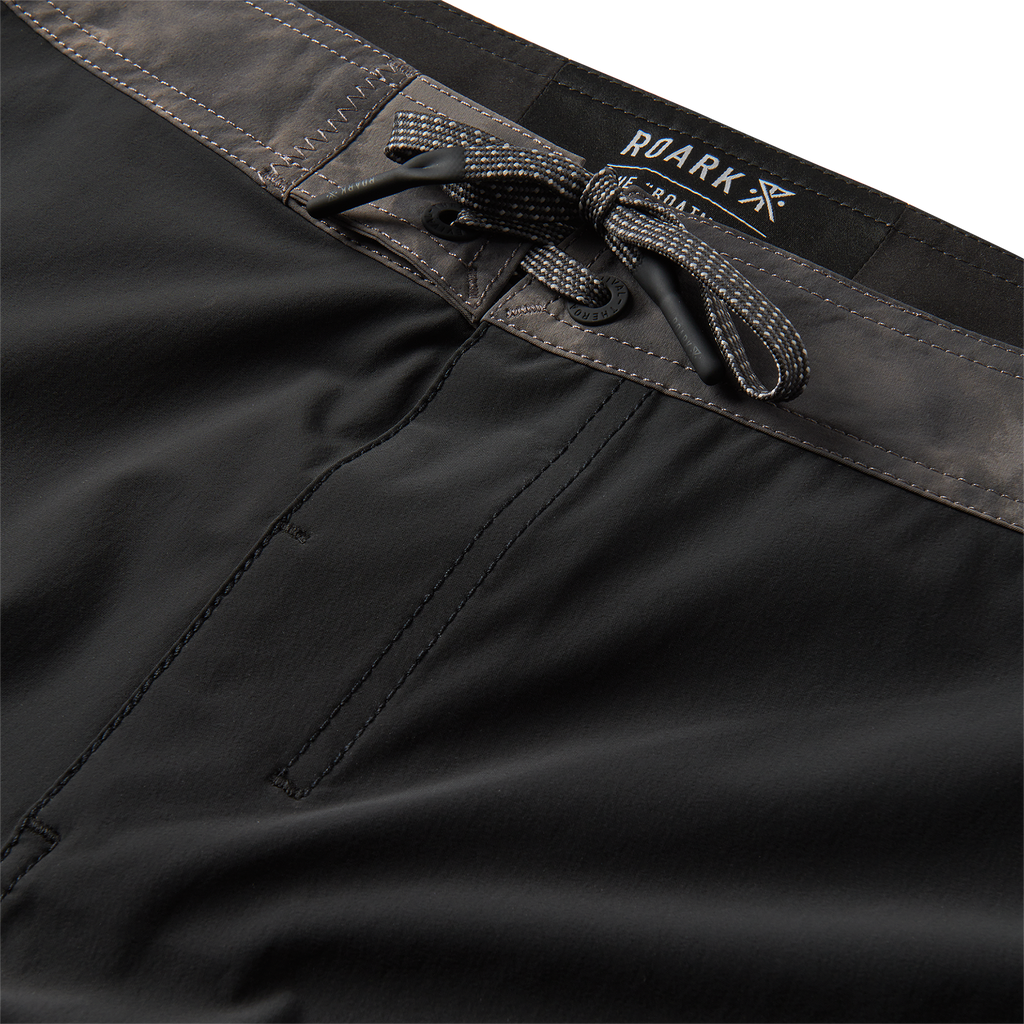 Close-up of the gray waistband with drawstring detail on black boardshorts, offering adjustable comfort and style. Big Image - 8