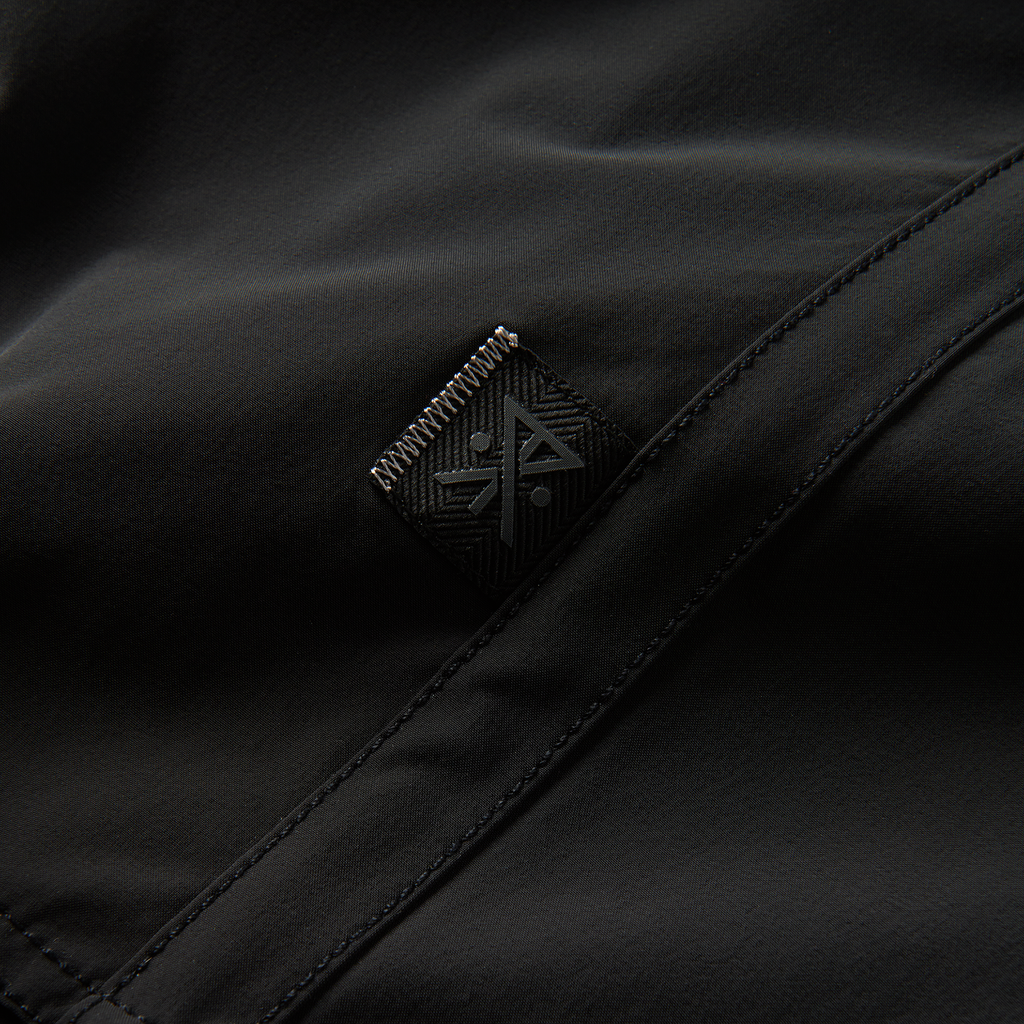 Zoomed-in view of the Roark logo and fabric detail on black boardshorts, highlighting premium craftsmanship and durability Big Image - 9