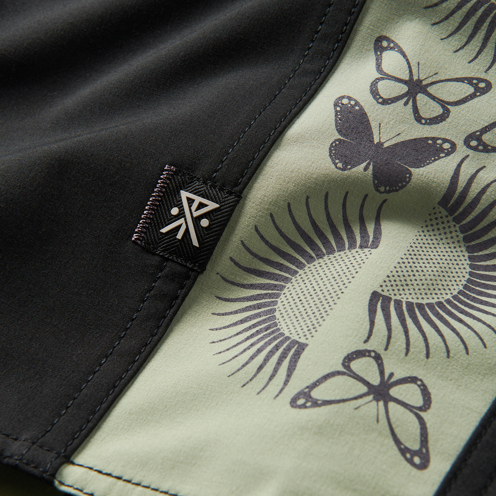 Close-up of butterfly and sun pattern details on black shorts for a bold, artistic vibe. Explore unique activewear style now! Big Image - 11