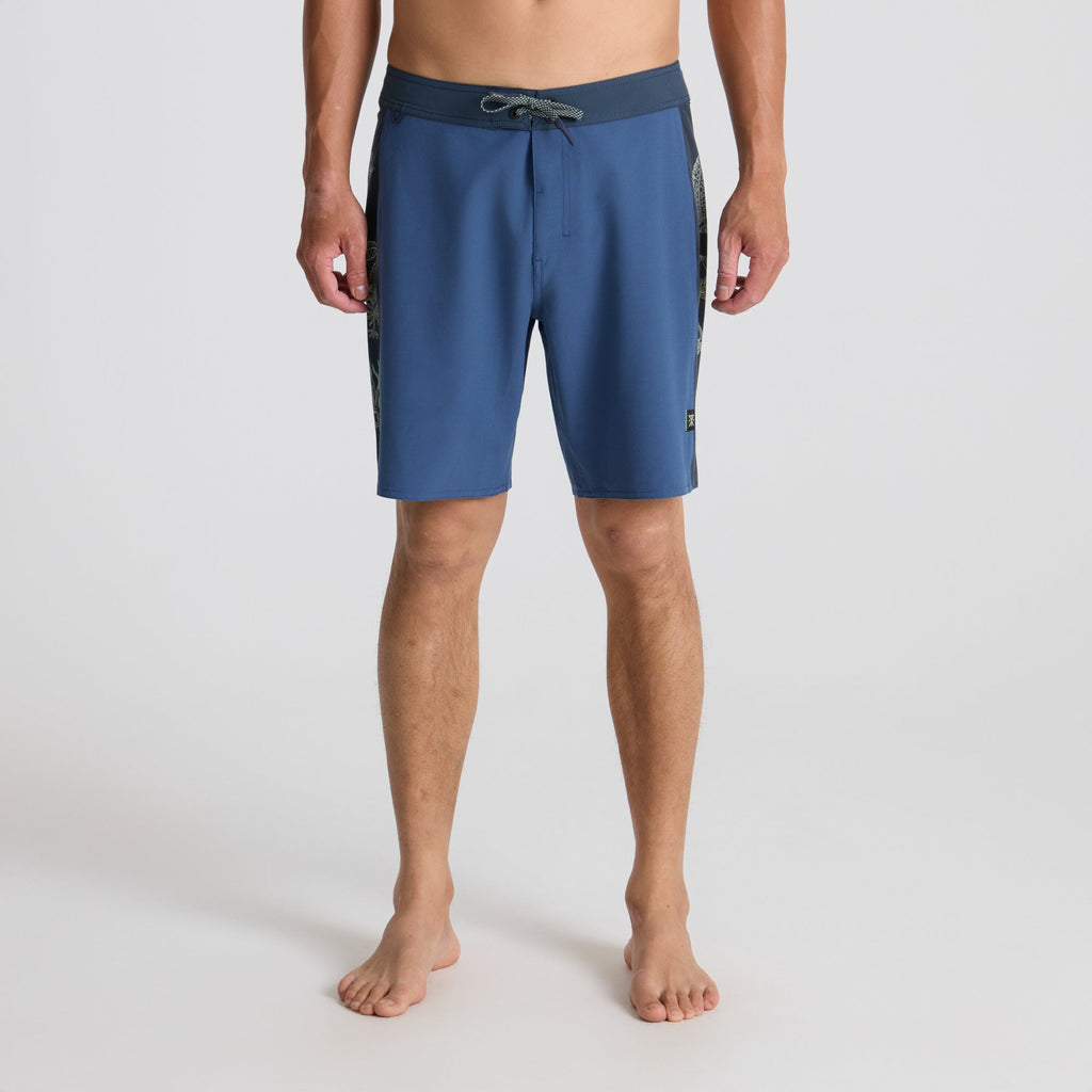 Man in tropical bay wearing Roark boardshorts, embodying a spirit of adventure and the outdoors. Big Image - 2