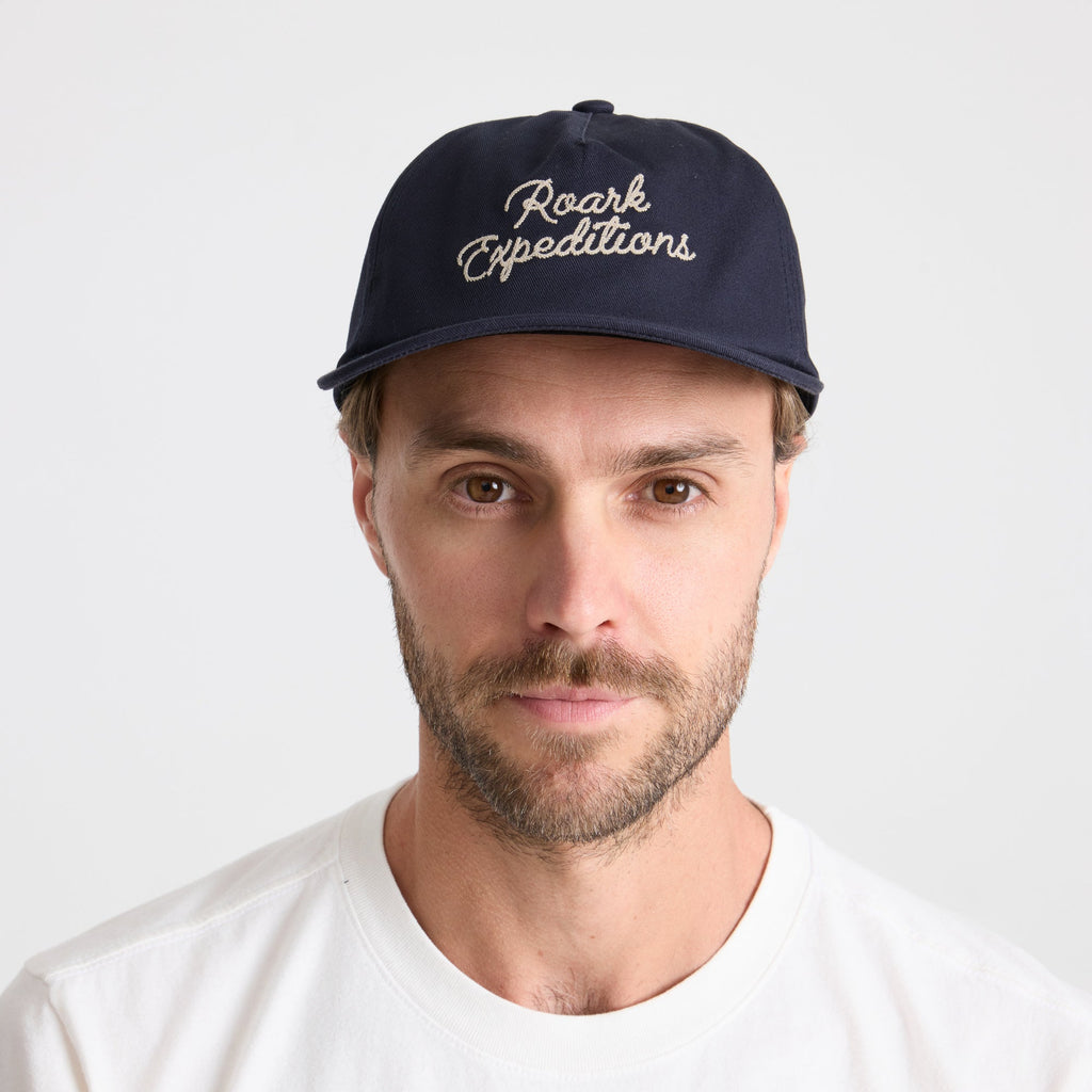 Stylish navy blue Roark baseball cap, perfect for outdoor adventures and travel, displayed against an adventurous backdrop. Big Image - 2