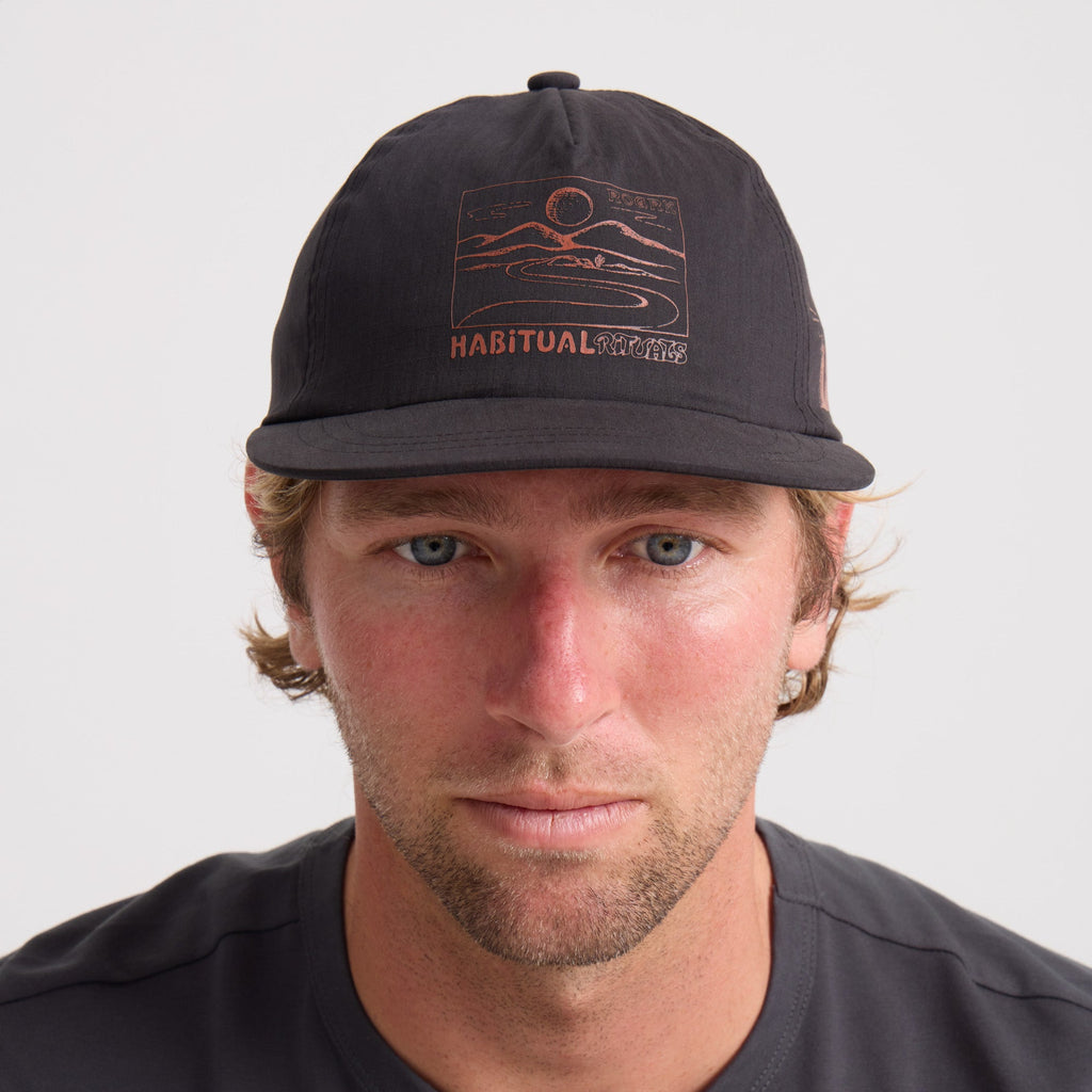 Man sporting rugged outdoor style with a black Roark baseball cap, accessorized with facial hair, embodying the adventure and travel spirit. Big Image - 2