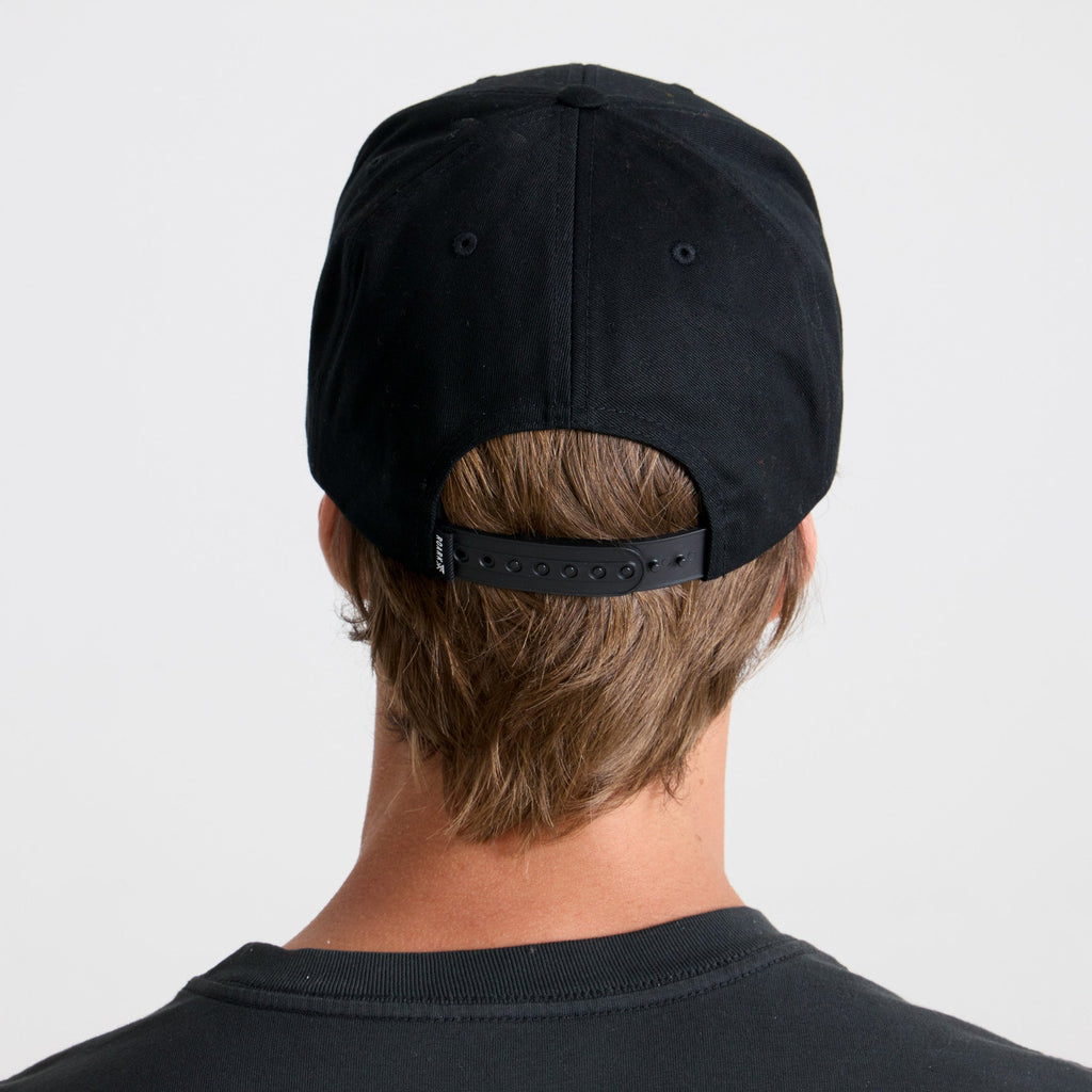 Black cricket cap placed on a rustic wooden surface, evoking a sense of adventure and travel, by Roark. Big Image - 5