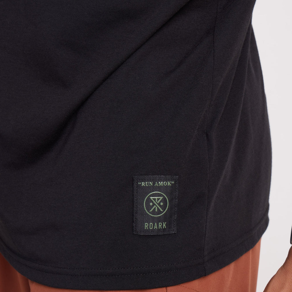 Close-up of the functional details on a Roark grey active shirt featuring a sleeve pocket, emphasizing durability and comfort for adventure travel. Big Image - 5