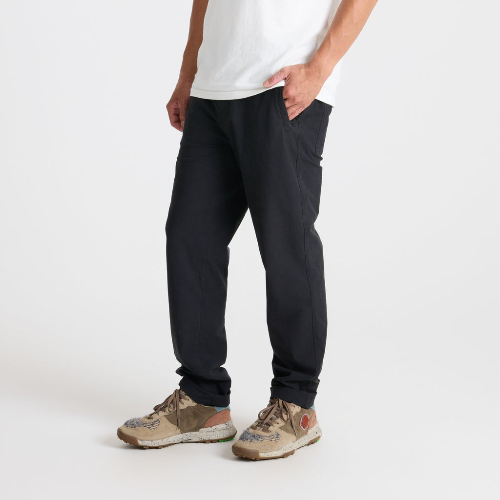 Group of adventurers walking through rugged terrain wearing durable Roark active pants and walking shoes, embodying the spirit of exploration. Big Image - 3