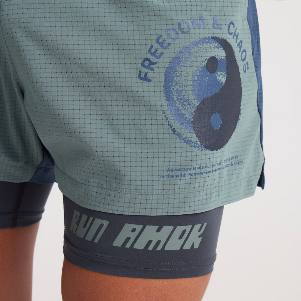 Man wearing Roark active shirt and Bermuda shorts while exploring rugged terrain Big Image - 6