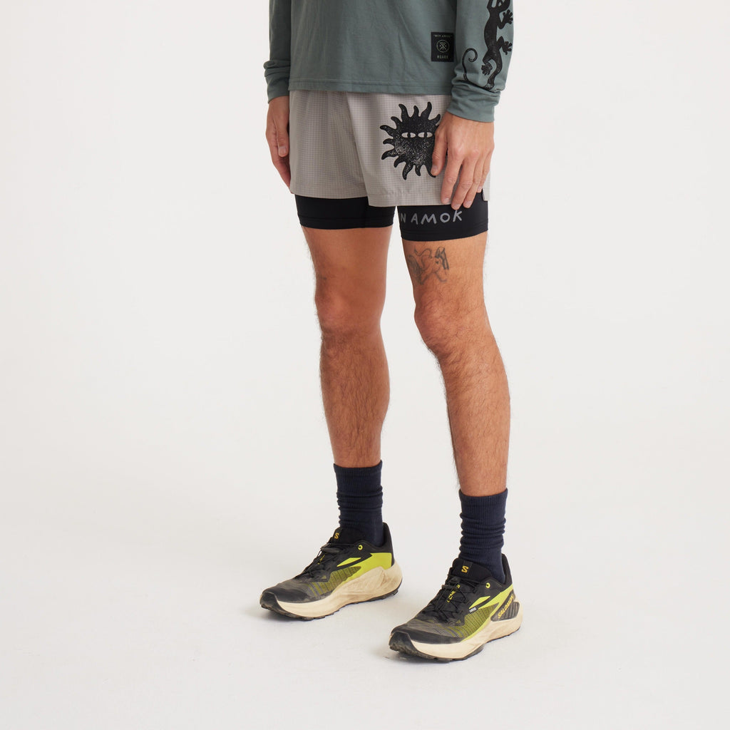 Side view of Roark running shorts featuring a stylish grey grid pattern, bold sun graphic, and black liner for versatility and performance. Big Image - 3