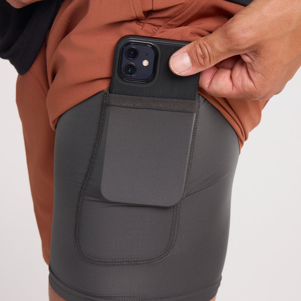 Adventurer using a mobile phone to navigate the terrain while a calf grazes nearby, blending technology with rural exploration. Big Image - 5