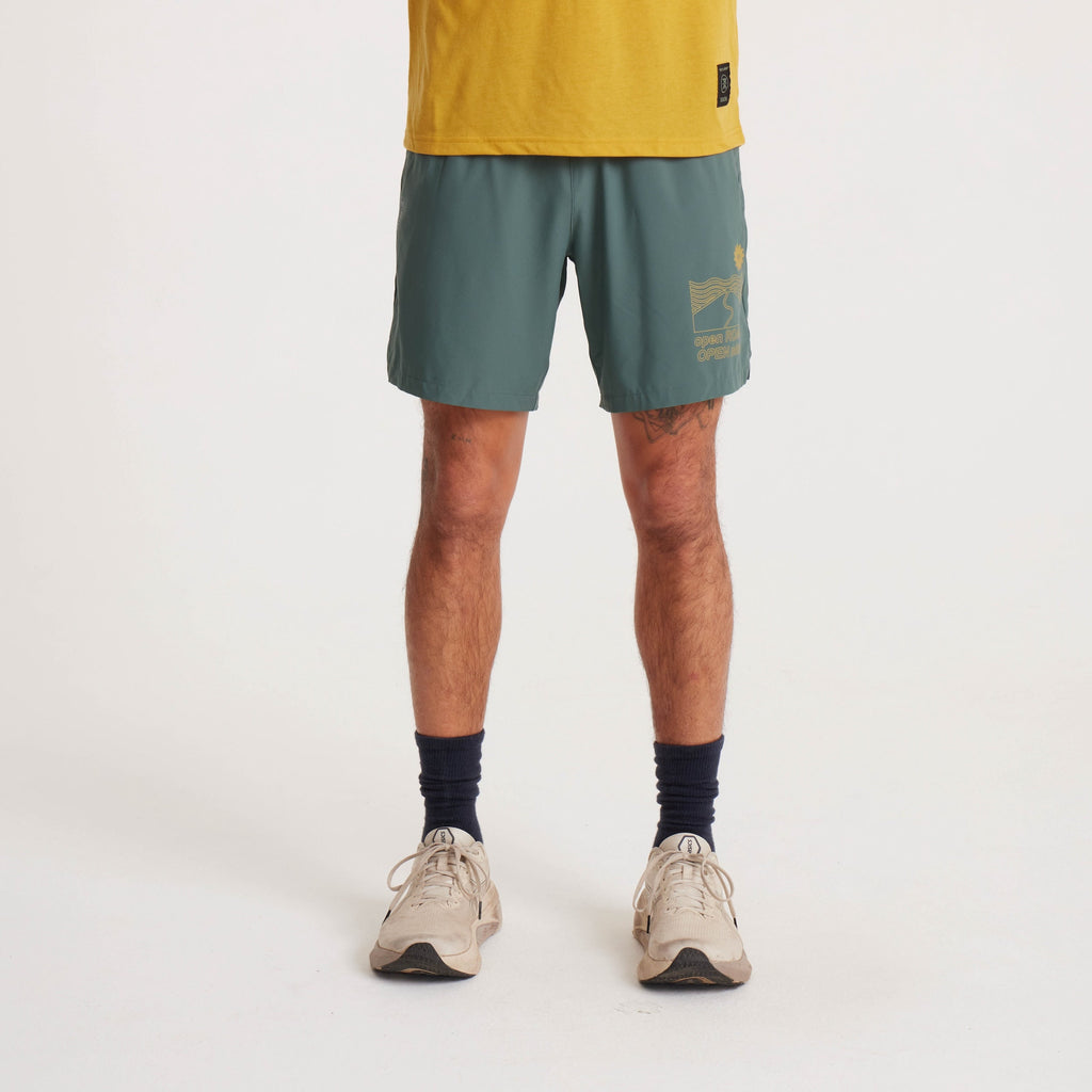 Front view of a male model showcasing green running shorts with a graphic detail and mustard yellow T-shirt. Big Image - 3