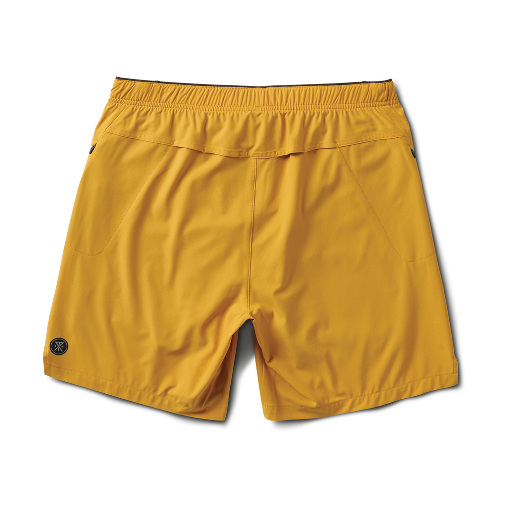 A man wearing the Roark Bommer 2.0 7" Shorts in Gold, demonstrating their comfortable fit and bold style for casual wear. Big Image - 2