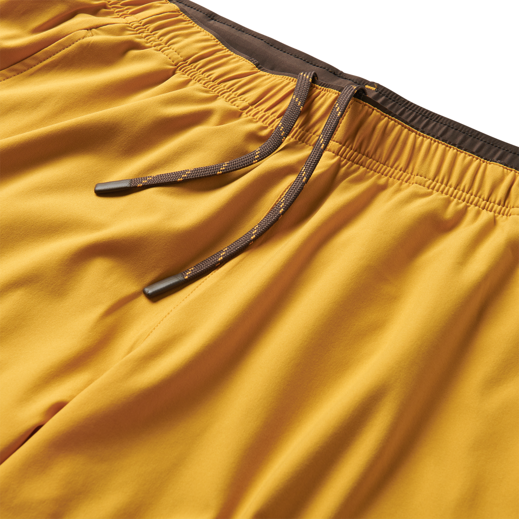 Close-up of the Roark Bommer 2.0 7" Shorts in Gold's fabric, emphasizing its lightweight and breathable nature for warm weather. Big Image - 3