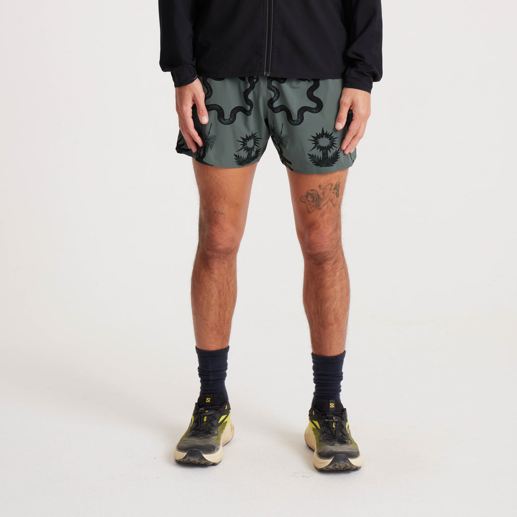 Model wearing green printed running shorts, showcasing a bold graphic design and perfect for activewear. Big Image - 2