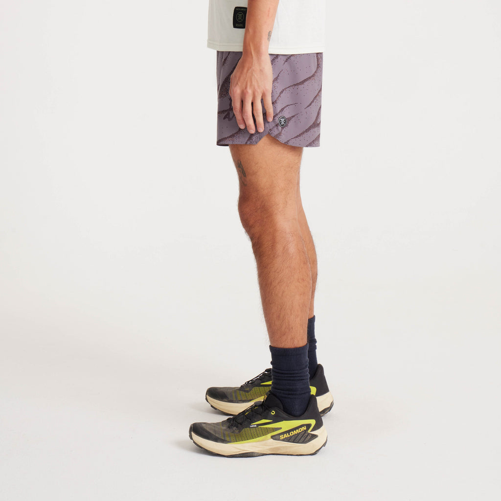 Side profile of men's running shorts in purple wave print, emphasizing sleek design and flexible fabric for active wear. Big Image - 4