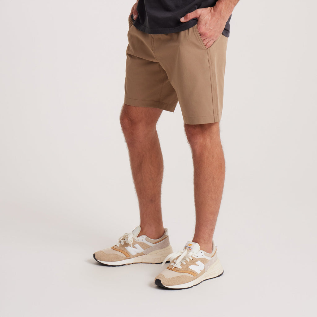 on-model Side angle of men's tan hybrid shorts, highlighting the flexible fabric and versatile style, ideal for both active and leisure activities. Big Image - 7