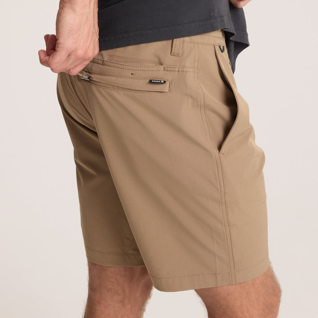 on-model Close-up of the back pocket of tan hybrid shorts with a zip closure, emphasizing secure storage for small essentials. Big Image - 9