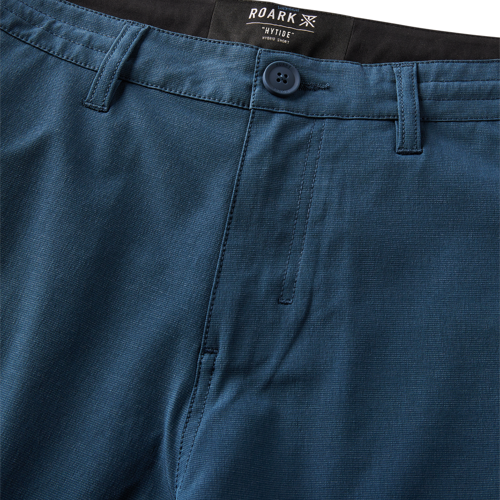 Man wearing a navy Roark adventure jacket while exploring a rugged coastal landscape Big Image - 10