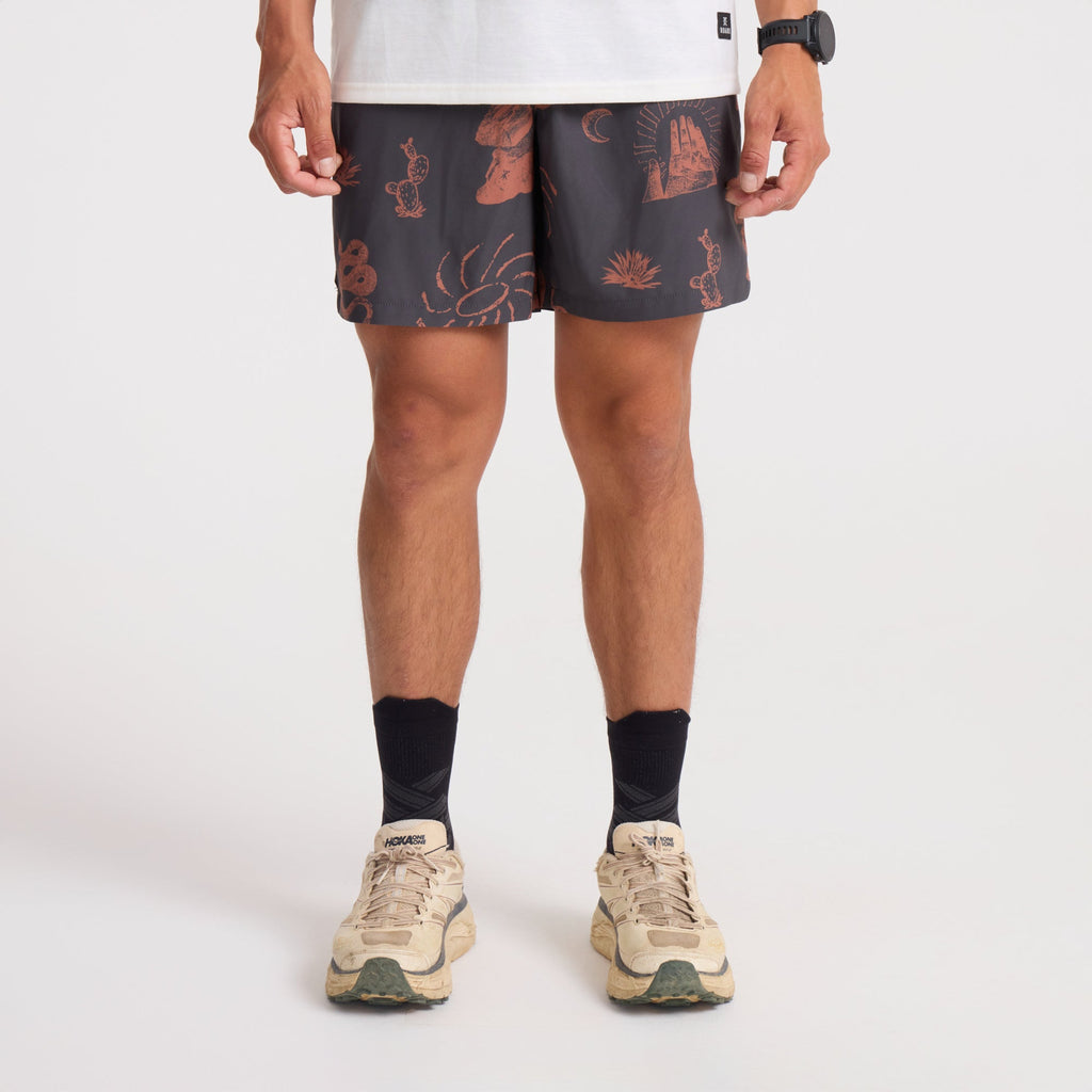 Man in brown and orange boardshorts, embodying the adventure and outdoor spirit of Roark, actively engaged in an outdoor setting. Big Image - 2