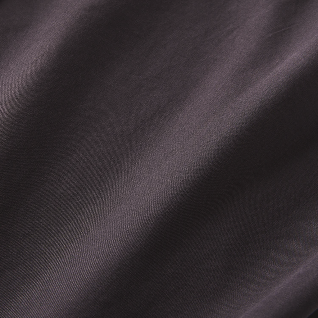 Textured fabric of the black button-up shirt, emphasizing its smooth finish and premium material quality. Big Image - 8