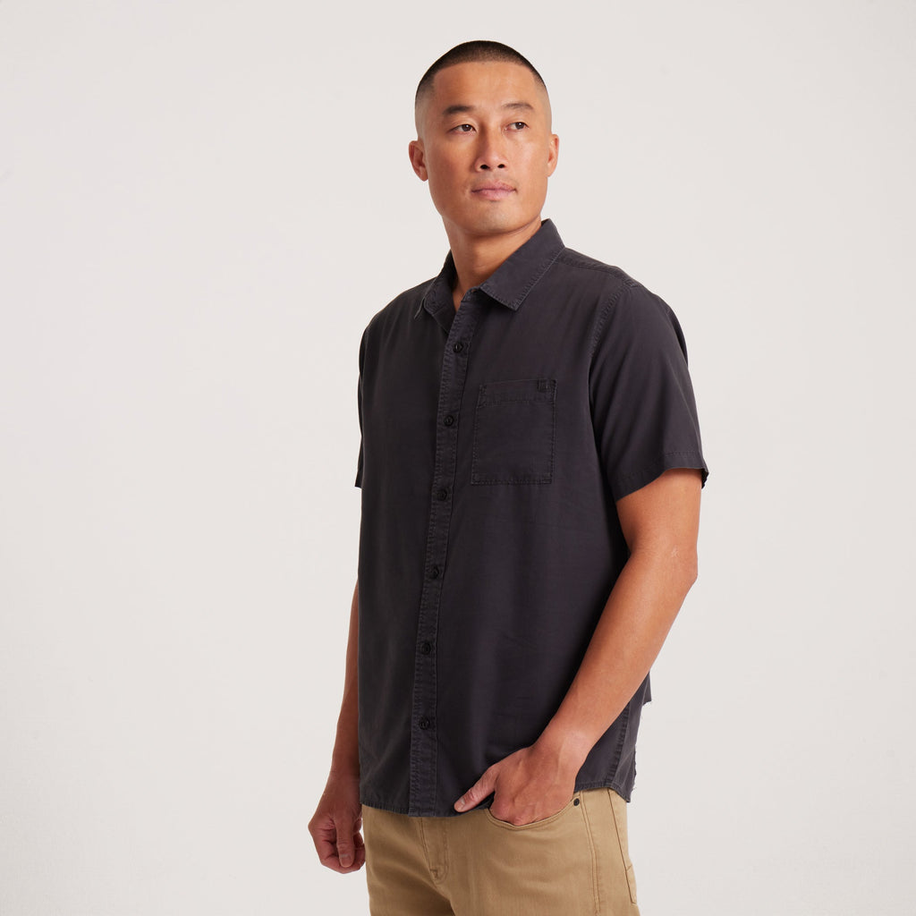 Side angle of a black short-sleeve button-up shirt with clean lines, showcasing a relaxed and modern fit. Big Image - 4