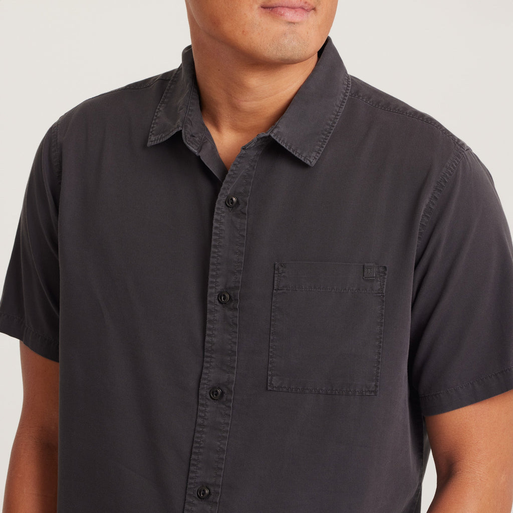 Close-up of the chest pocket and buttons on a black short-sleeve button-up shirt, highlighting the quality and detailing. Big Image - 5