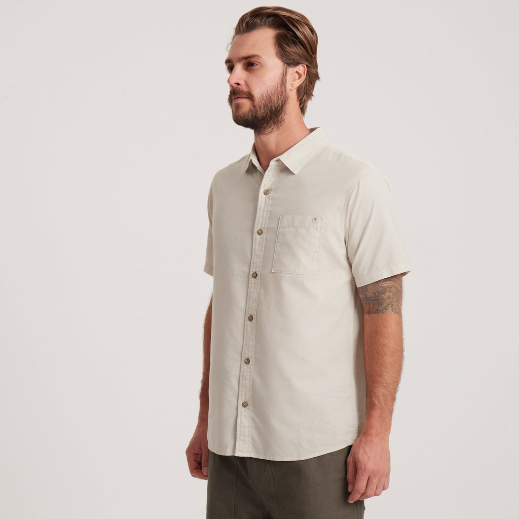 Angled side view of an off-white short-sleeve button-down shirt for men, ideal for warm-weather outings and smart-casual occasions. Big Image - 7