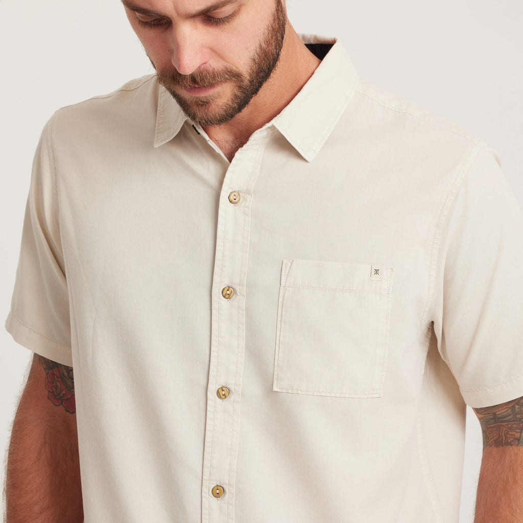 Close-up of a men's short-sleeve button-down shirt in off-white, featuring a chest pocket and natural buttons for a clean, minimalist look. Big Image - 5