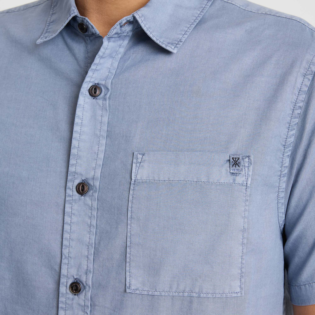 Close-up of a denim dress shirt featuring a pointed collar, button details, and chest pocket, embodying Roark's rugged adventure-ready style. Big Image - 7