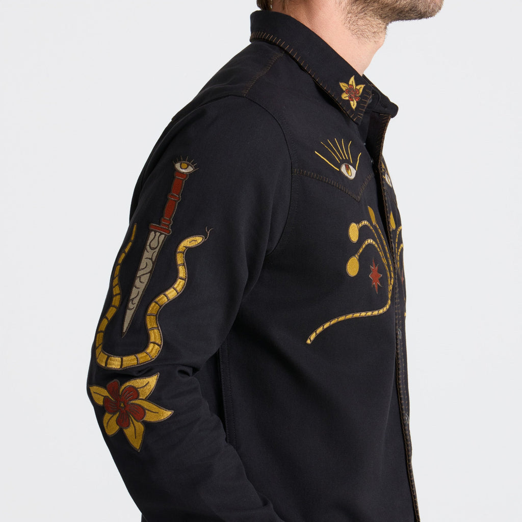 Close-up view of a durable black button, detailing on Roark adventure gear. Big Image - 8