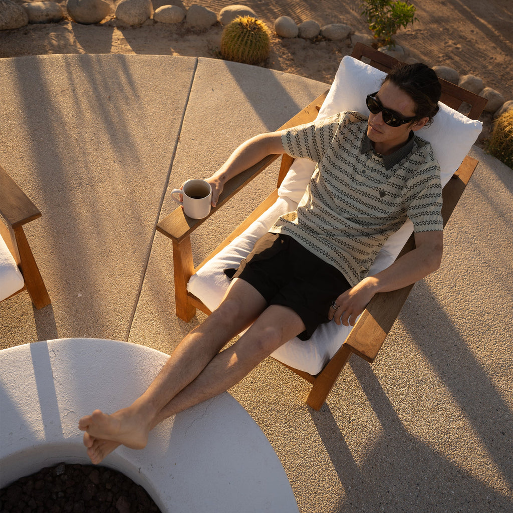 life-style-image Relaxed outdoor setting with comfortable furniture, featuring a person sitting while wearing a hat, embodying Roark's adventure and travel lifestyle. Big Image - 3