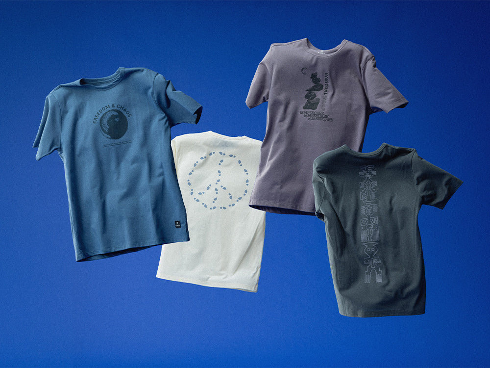 Four t-shirts in different colors on a blue background