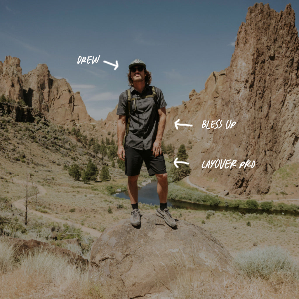 Man standing on a rock with mountainous landscape in the background, wearing outdoor gear. Big Image - 2