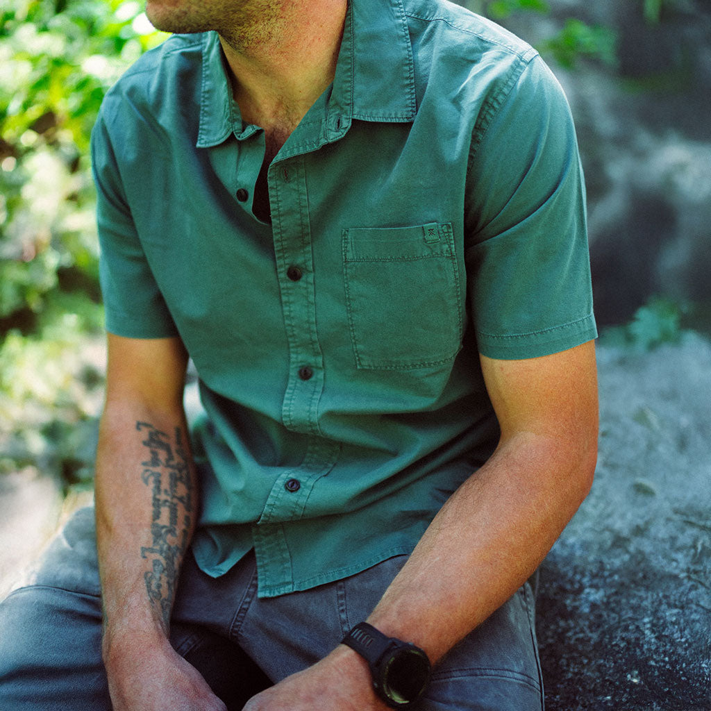 Person wearing a green shirt sitting outdoors with a natural background Big Image - 2