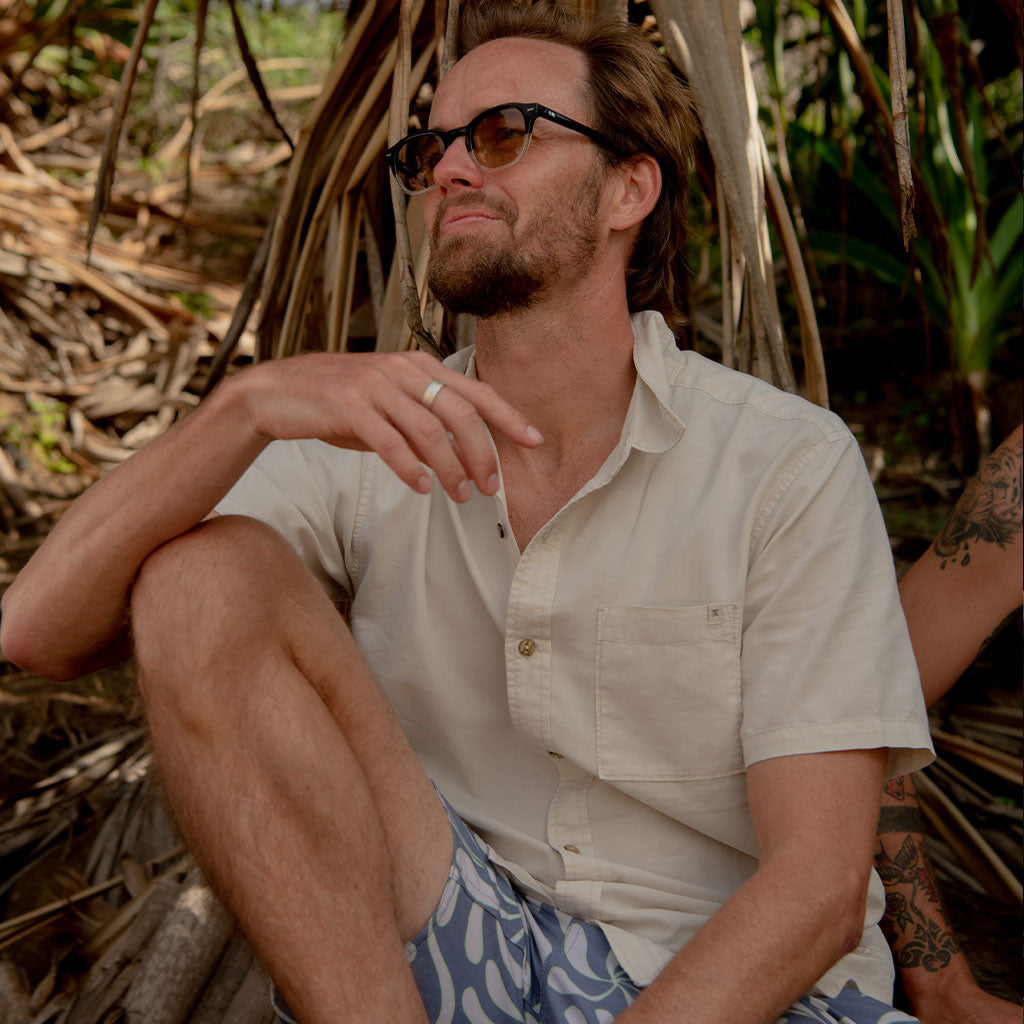 Man sitting outdoors wearing sunglasses and a light shirt Big Image - 2