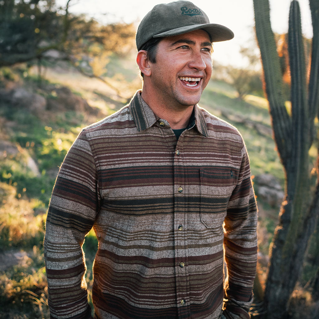 Guy in a brown stripe Roark flannel shirt with cactus in the background Big Image - 2